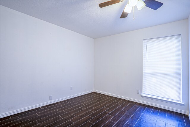 unfurnished room featuring ceiling fan, dark hardwood / wood-style flooring, and a textured ceiling