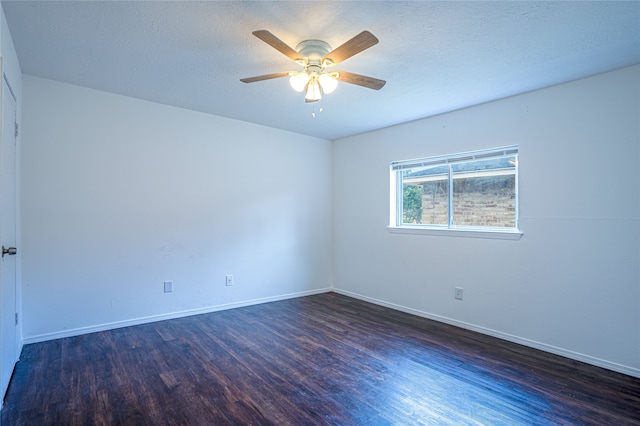 empty room featuring a textured ceiling, dark wood-type flooring, and ceiling fan