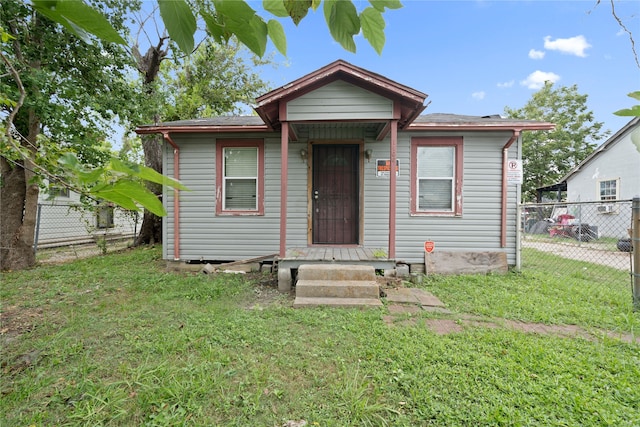 bungalow-style house featuring a front lawn