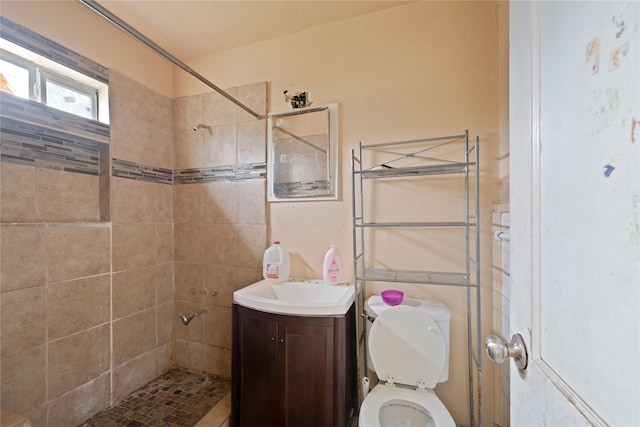 bathroom with vanity, toilet, and a tile shower