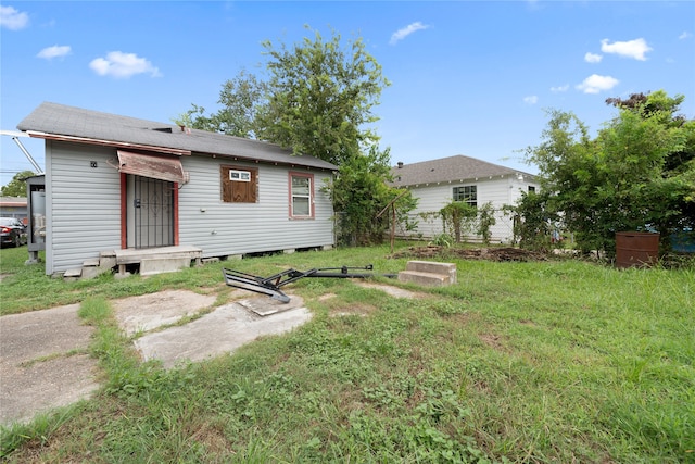 rear view of house featuring a yard