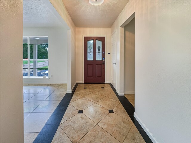 foyer featuring light tile patterned floors and a textured ceiling