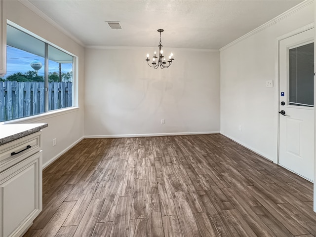 unfurnished dining area featuring crown molding, dark wood-type flooring, and a notable chandelier