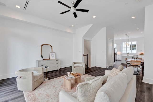 living room with dark wood-type flooring and ceiling fan