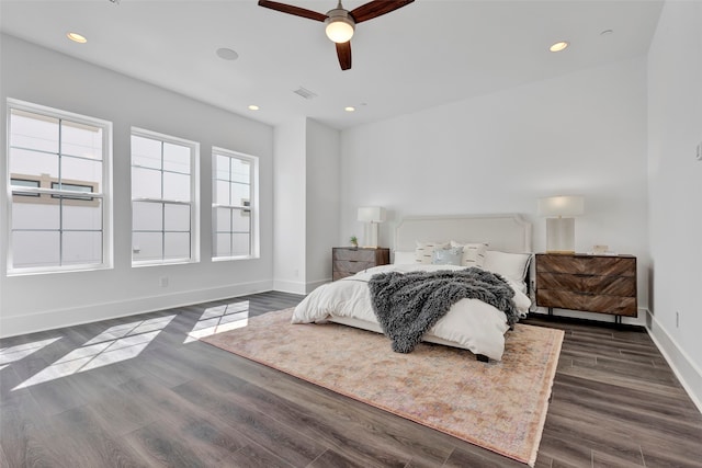 bedroom with dark wood-type flooring, multiple windows, and ceiling fan