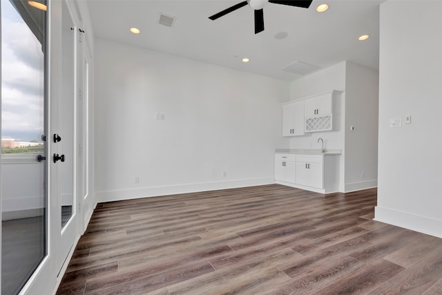 unfurnished living room featuring ceiling fan, wood-type flooring, and sink