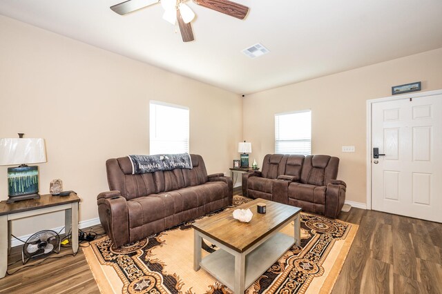 living room featuring ceiling fan and dark hardwood / wood-style floors