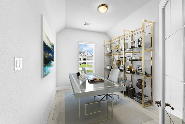 office space with lofted ceiling, a textured ceiling, and light hardwood / wood-style floors