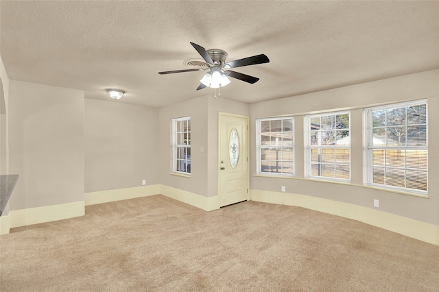 carpeted spare room featuring a textured ceiling and ceiling fan