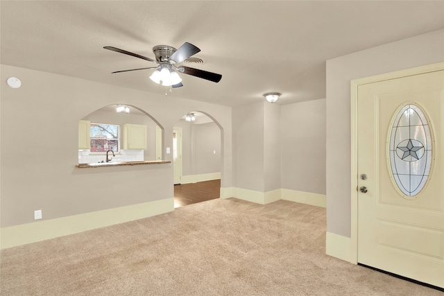 carpeted entrance foyer with ceiling fan