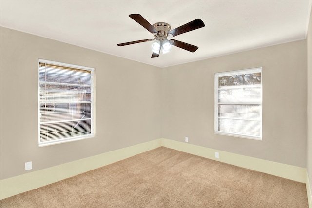 carpeted empty room featuring ceiling fan and plenty of natural light