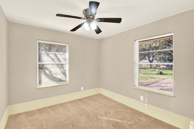 unfurnished room with plenty of natural light, ceiling fan, and carpet