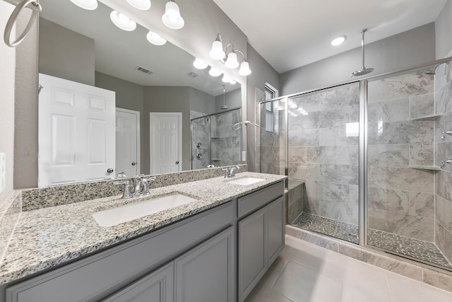 bathroom with tile patterned flooring, a shower with door, and vanity