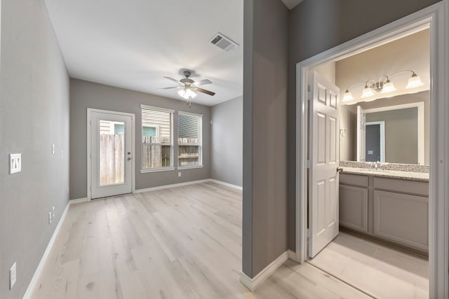 entryway with ceiling fan, light hardwood / wood-style floors, and sink