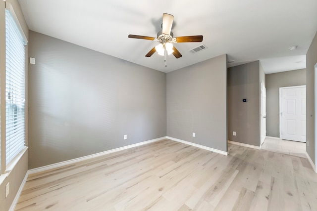 spare room with light hardwood / wood-style flooring, ceiling fan, and a healthy amount of sunlight