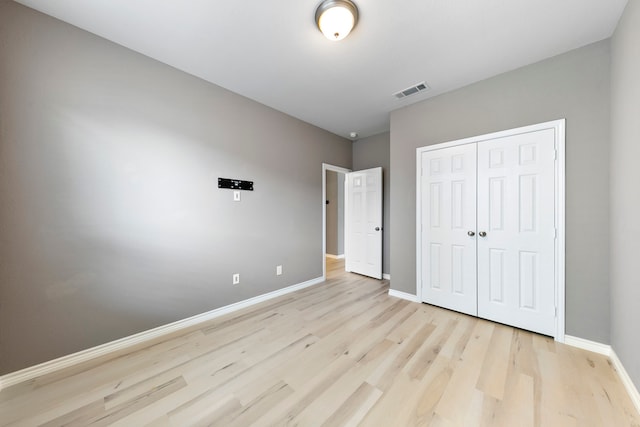 unfurnished bedroom featuring a closet and light hardwood / wood-style floors