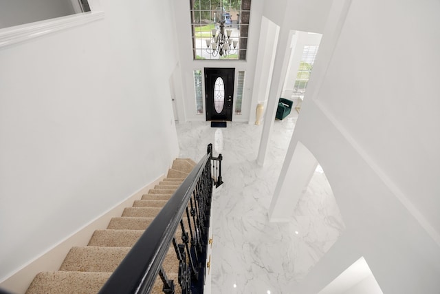 stairs with a notable chandelier