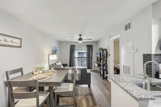 dining space featuring visible vents, ceiling fan, and wood finished floors