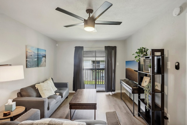 living room with light hardwood / wood-style flooring and ceiling fan