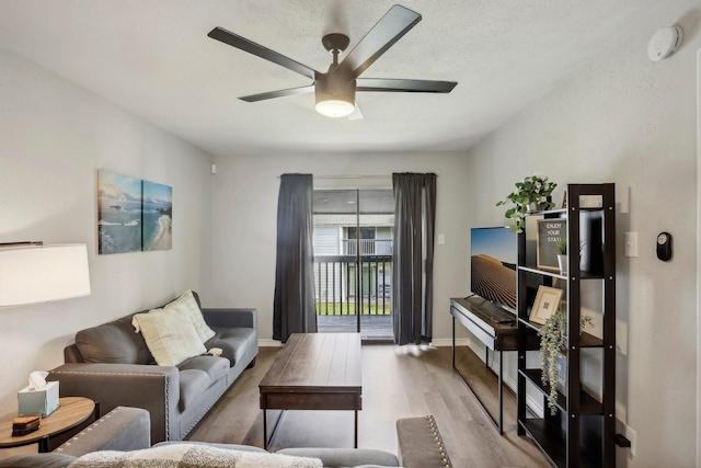 living area with ceiling fan, baseboards, and wood finished floors