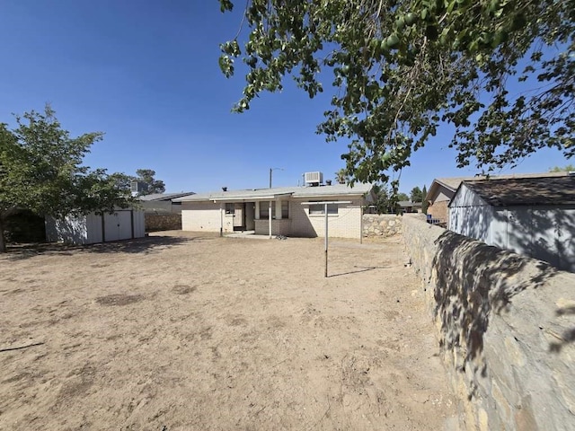 back of property with a storage shed