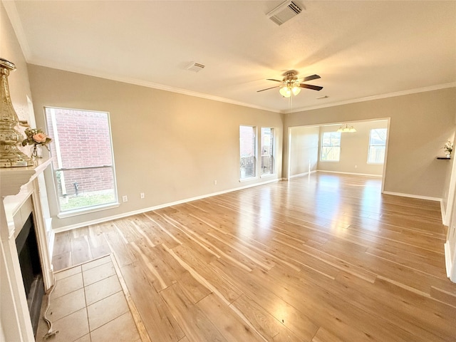 unfurnished living room featuring ceiling fan, a healthy amount of sunlight, ornamental molding, and light hardwood / wood-style flooring