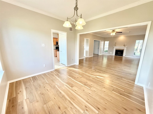 unfurnished living room featuring ceiling fan with notable chandelier, light hardwood / wood-style floors, and crown molding