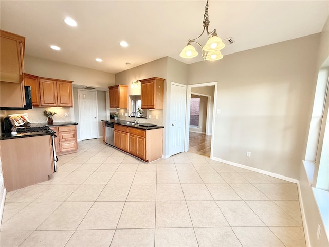 kitchen with sink, a notable chandelier, pendant lighting, light tile patterned floors, and appliances with stainless steel finishes