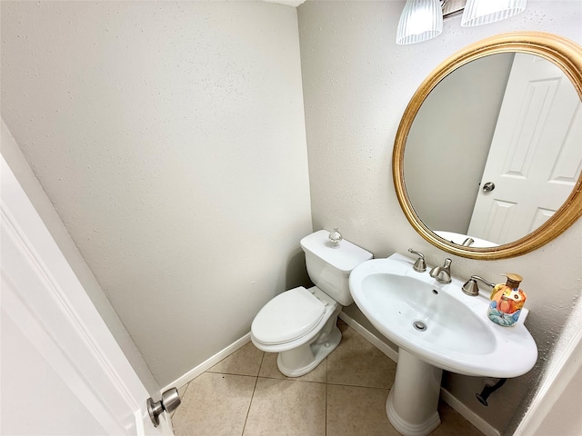 bathroom with tile patterned flooring, toilet, and sink