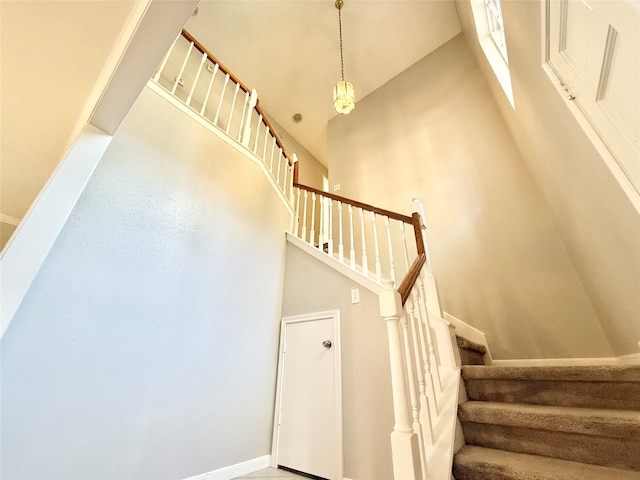 staircase with high vaulted ceiling