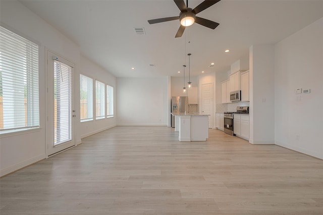 unfurnished living room with ceiling fan and light hardwood / wood-style flooring