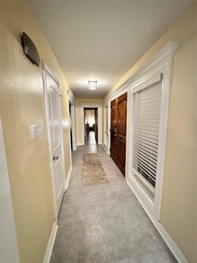 corridor featuring carpet flooring and baseboards