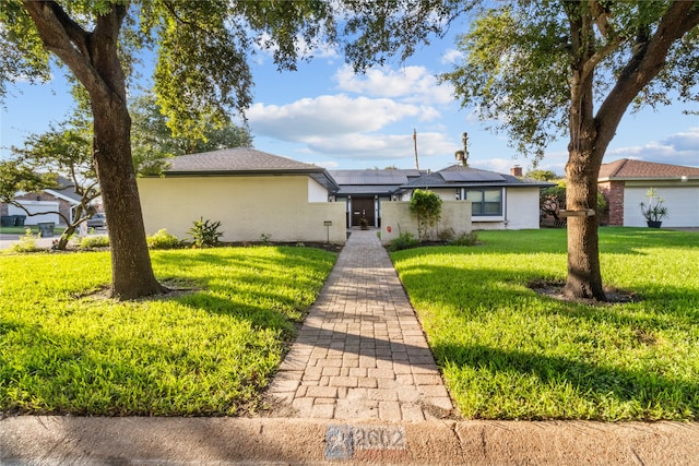 ranch-style home featuring a front yard and solar panels