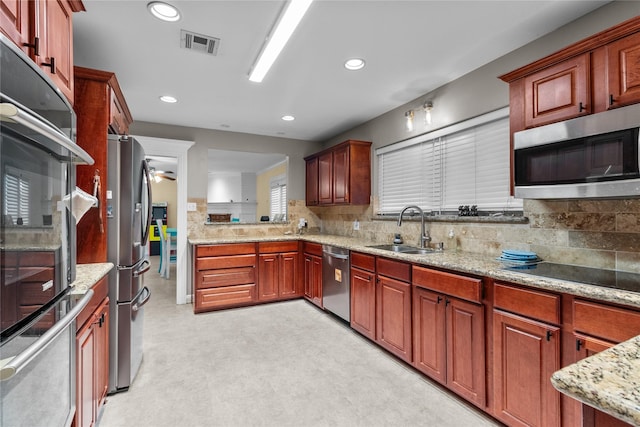 kitchen featuring light stone countertops, light floors, visible vents, a sink, and appliances with stainless steel finishes