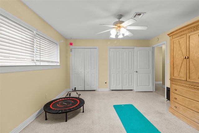 exercise room featuring baseboards, visible vents, and ceiling fan