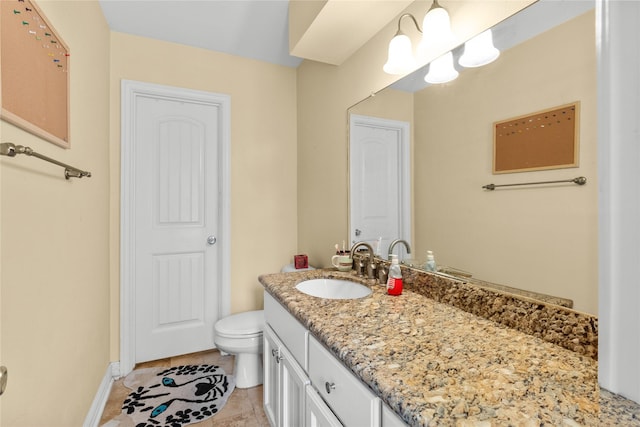 bathroom with baseboards, toilet, and vanity