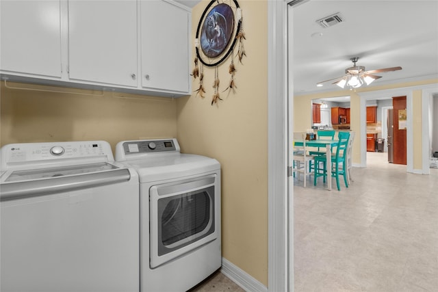 washroom with cabinet space, visible vents, washer and dryer, and baseboards