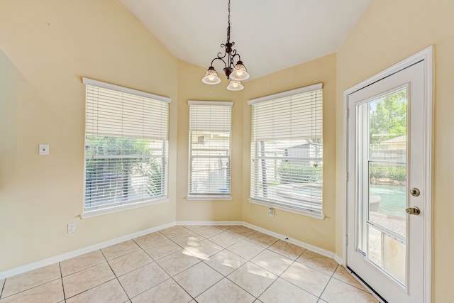 unfurnished dining area featuring an inviting chandelier, vaulted ceiling, and light tile patterned floors