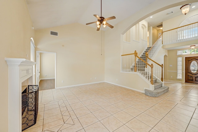 unfurnished living room featuring high vaulted ceiling, ceiling fan, and light tile patterned floors