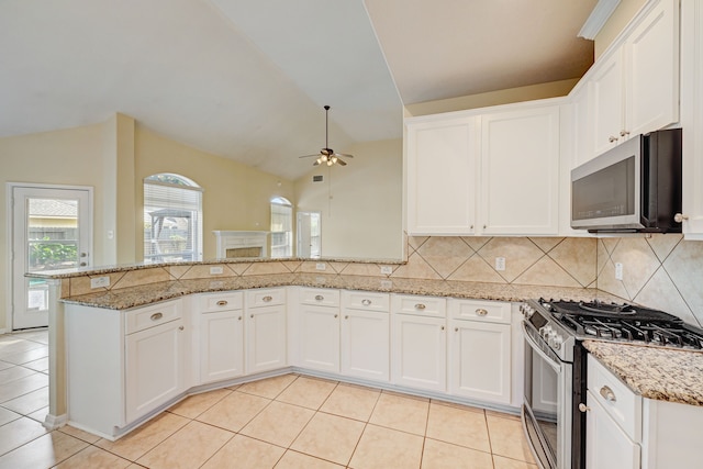 kitchen featuring stainless steel appliances, vaulted ceiling, and white cabinets