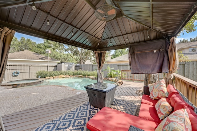 wooden terrace featuring a pool with hot tub and a gazebo