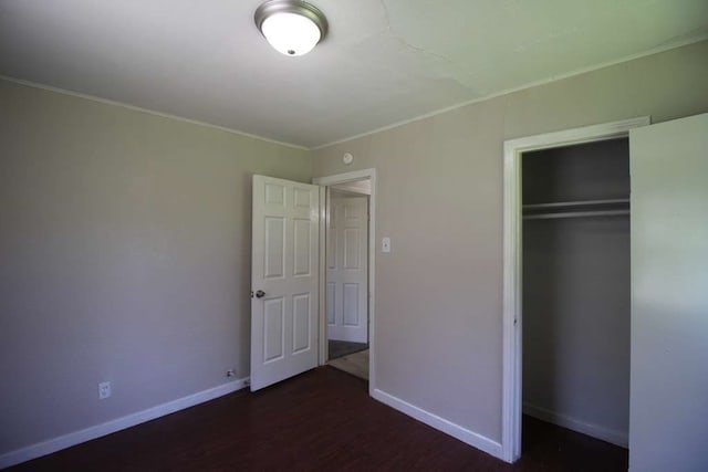 unfurnished bedroom with a closet and dark hardwood / wood-style floors