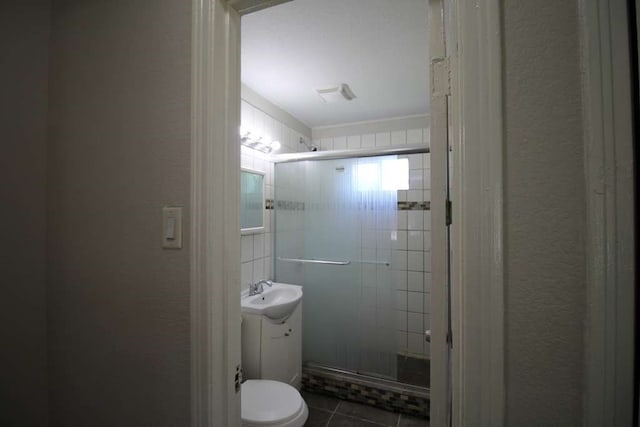 bathroom featuring vanity, toilet, walk in shower, and tile patterned floors