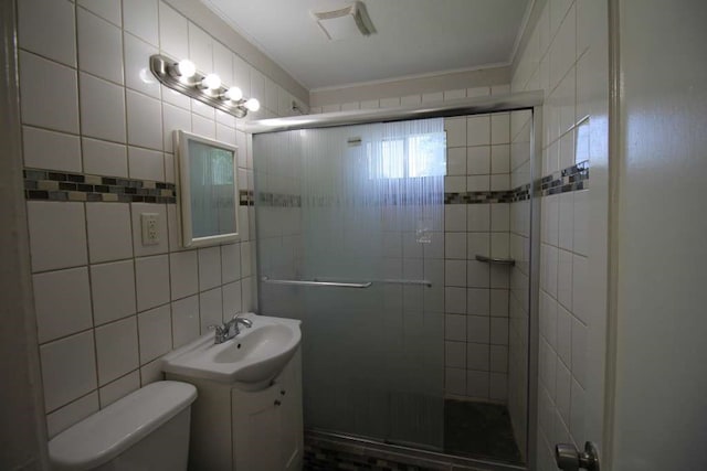 bathroom with toilet, a shower with door, crown molding, vanity, and tile walls