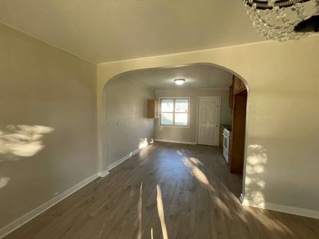 1507 Demaree Ln, Houston, TX 77029 - unfurnished living room with arched walkways, dark wood-style floors, baseboards, and ornamental molding