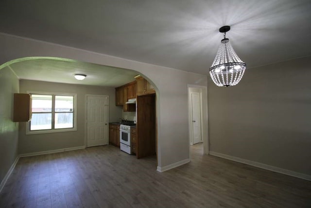 kitchen with pendant lighting, dark wood-type flooring, white gas range, and a notable chandelier