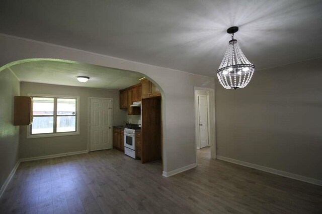 1507 Demaree Ln, Houston, TX 77029 - kitchen with arched walkways, white gas range oven, baseboards, and light wood-style flooring
