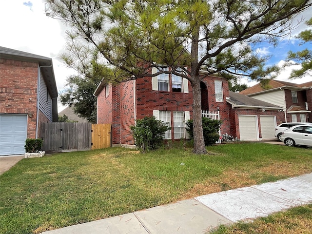 traditional-style home featuring an attached garage, brick siding, fence, and a front lawn