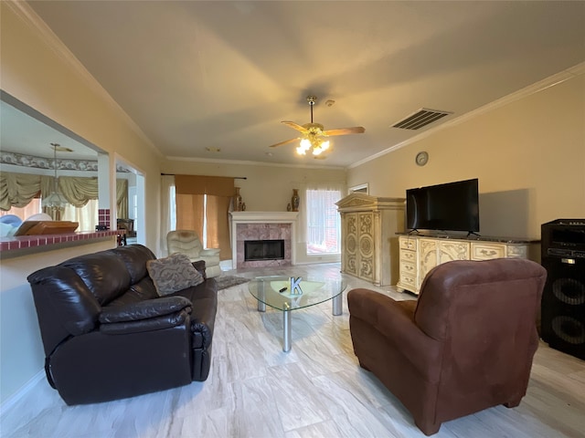 living room with a fireplace, ornamental molding, hardwood / wood-style floors, and ceiling fan