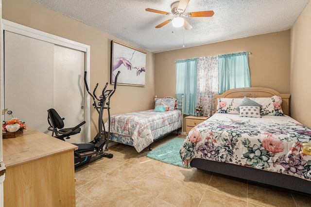 tiled bedroom featuring ceiling fan and a textured ceiling